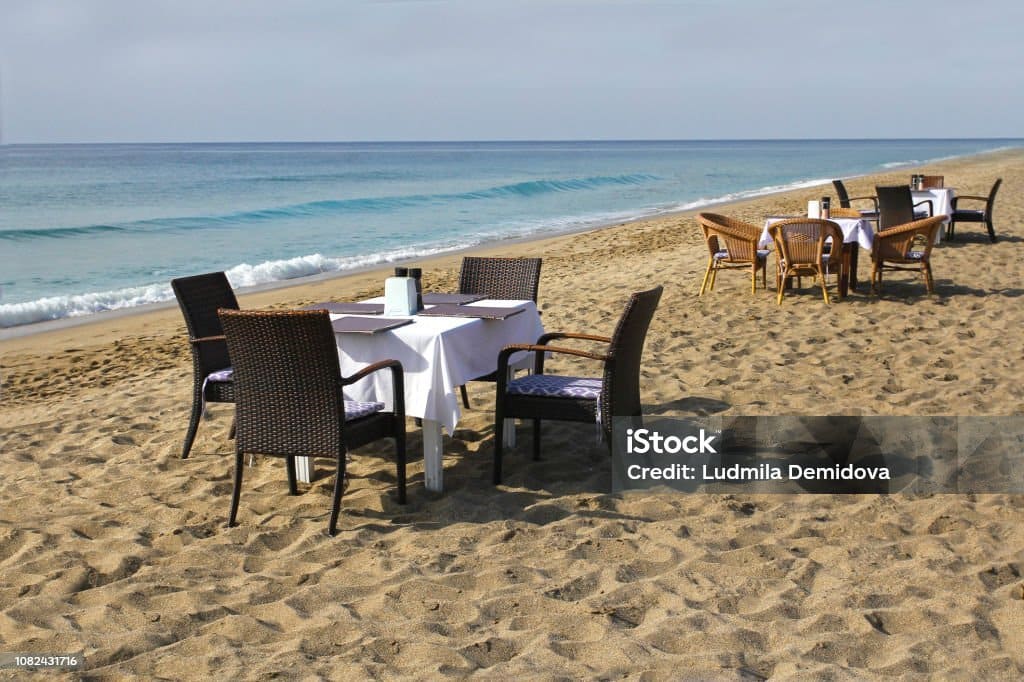 Dining by the beach with a stunning view, featuring sunset and vibrant coastal atmosphere.